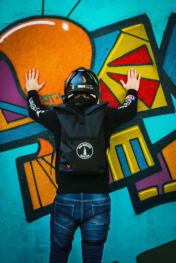 Rider met 076 Bikers rugzak tegen een graffitimuur